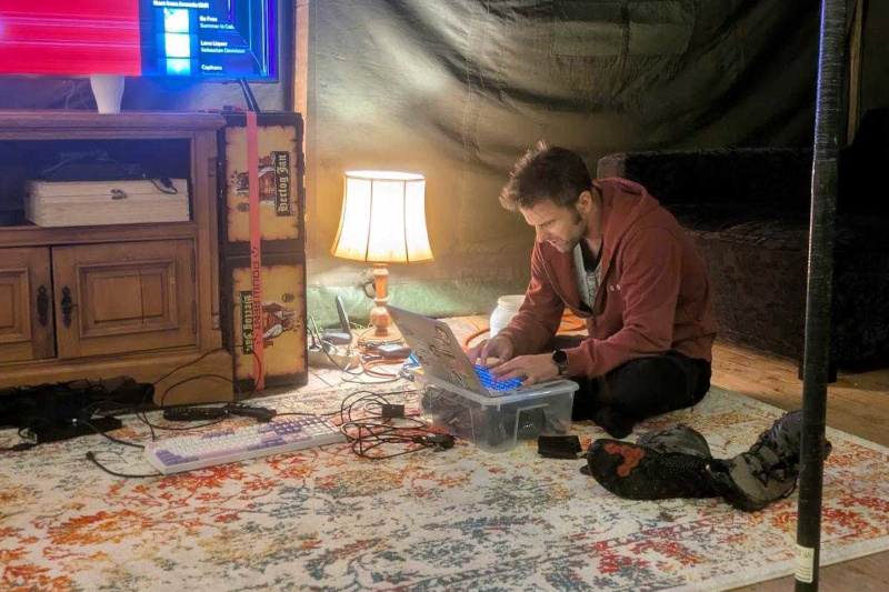 Operations at work on a laptop in side a big tent, fixing a nightly outage